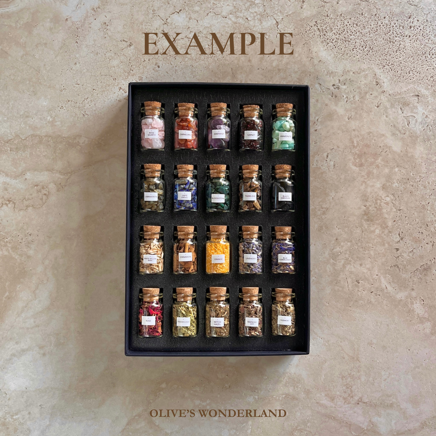 Set of small glass jars with labels arranged in a grid on a beige stone surface, branded 'Olive's Wonderland'.